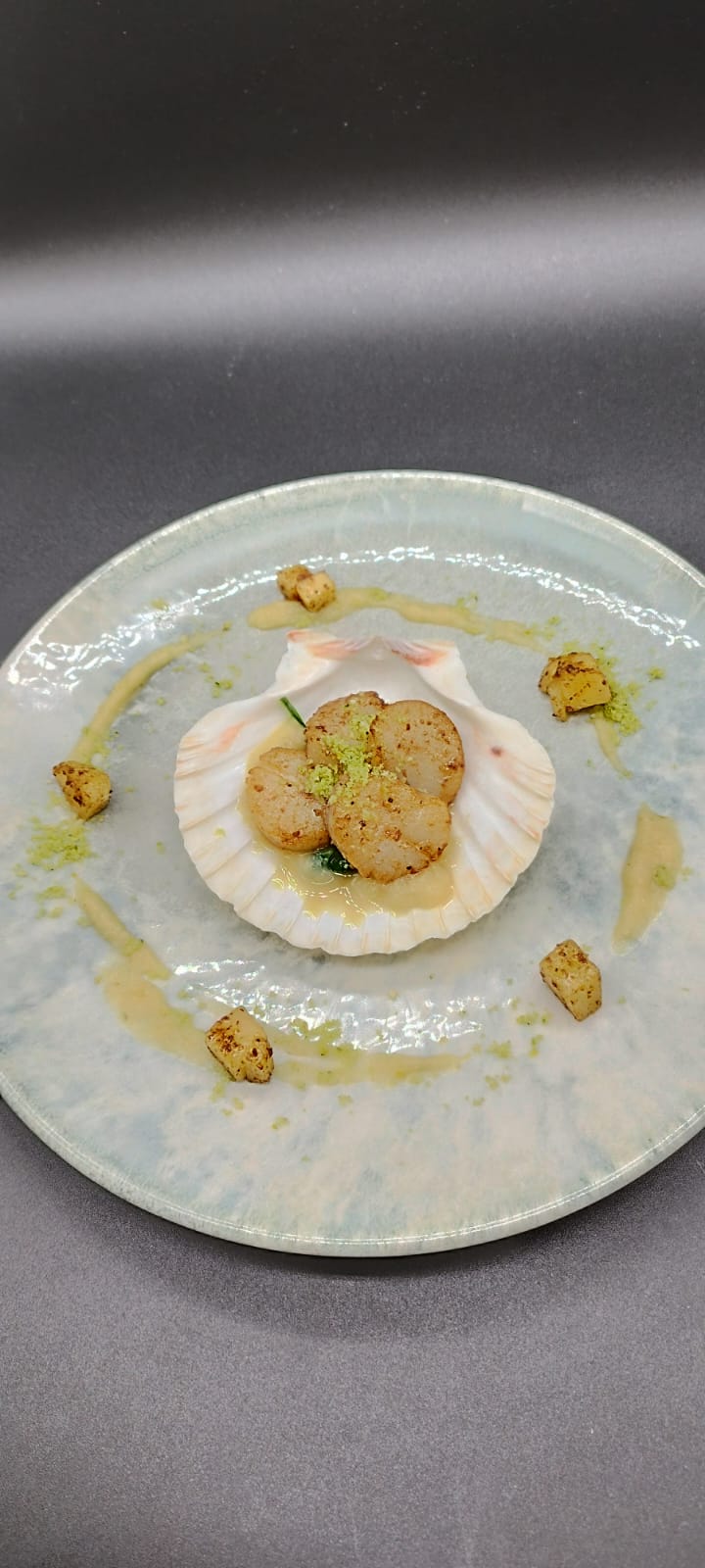 Seared scallops served in the shell with herb crumb