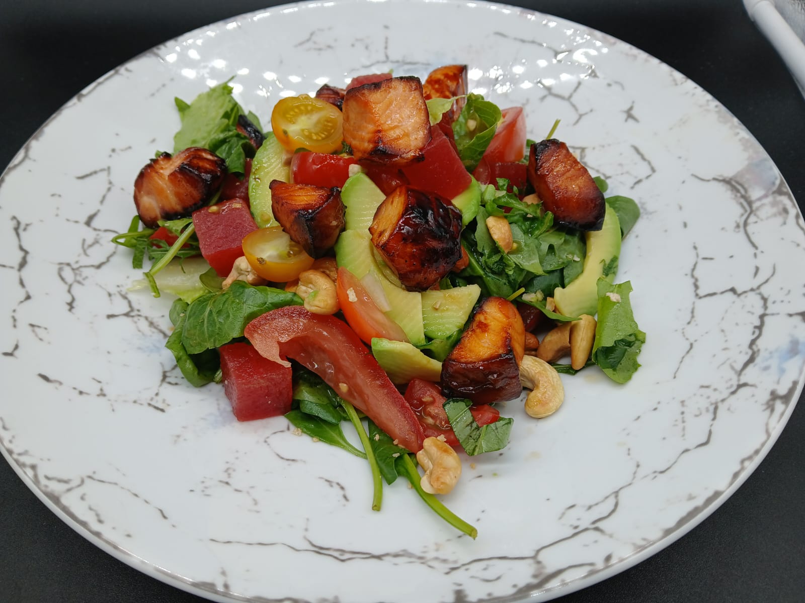 Glazed salmon salad with watermelon, avocado and cashews