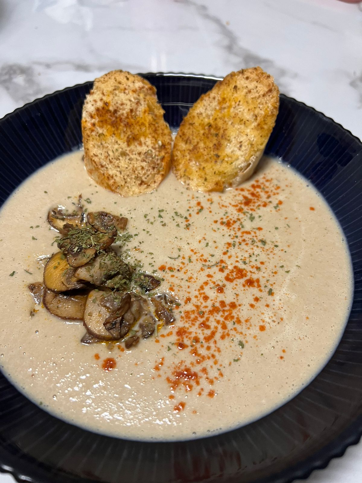 Creamy mushroom soup with sauteed mushrooms and toasted bread